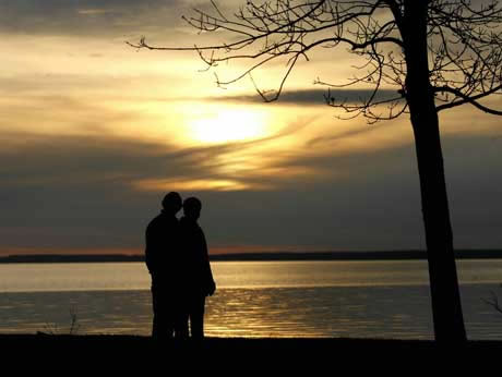 Couple standing on a beach at sunset